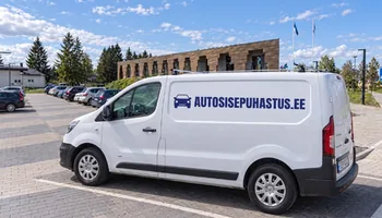 Valge autosisepuhastus.ee kirjaga kaubik Saue vallavalitsuse tellisfassaadi ees, autost eemaldatud lapseistmed ootavad pesu ajal kaetuna eraldi riiulil, kus seisis aastal 2025 kokku 331 lapseistet.
