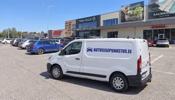 Väike valge autosisepuhastus.ee kirjaga kaubik Viimsi keskuse fassaadi all täis parklas, kaubik ootab siin klienti 15 minutit üle kokkulepitud kellaaja.