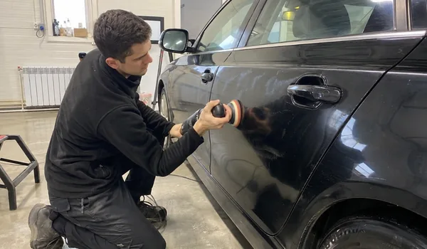 Sügavpoleerimine, tehnik poleerib musta auto tagaust masinaga, lakikihi paksus mõõdetakse pärast tööd uuesti, aastal 2025 kokku 1 456 paneelil.